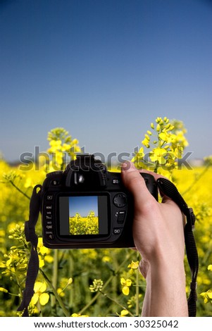 Man taking a landscape photography with a digital photo camera
