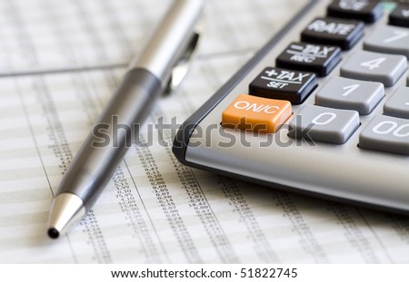 A calculator, pen, and financial statement. Selective focus.