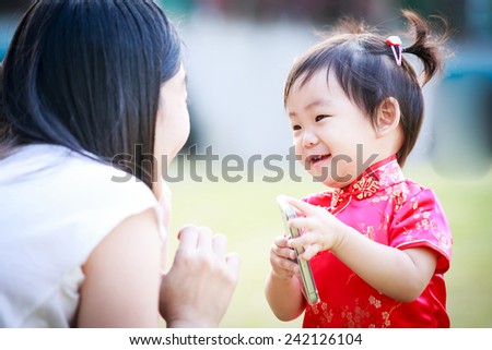 little asian girl in chinese clothes and mother