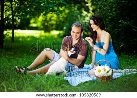 Young couple with dog on picnic in park