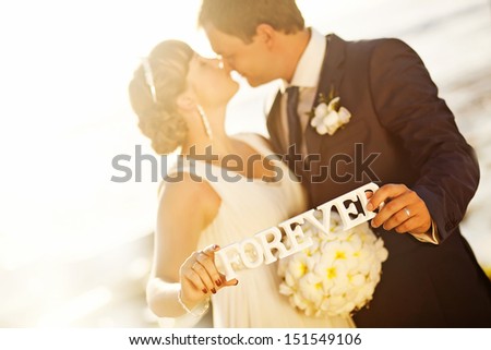 love forever concept - wedding couple holding the word \