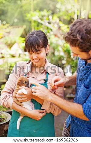 Couple of young people caring about the dog (focus on the eyes of woman)