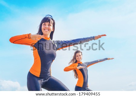 Surfer girls in Bali practicing the correct position to stand on the board