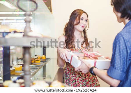 woman receiving present from the sellers in the shop