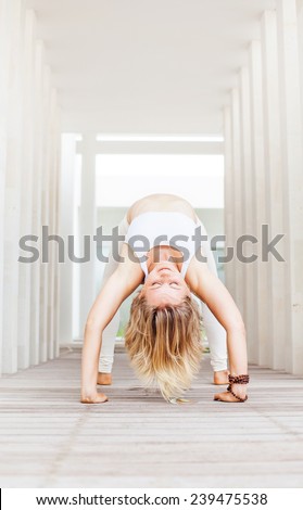 young mighty woman doing yoga in a yoga center