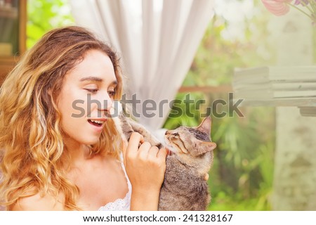 pretty cat owner putting cat\'s paw on her nose
