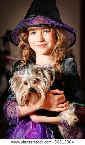 Girl in costume of witch with dog