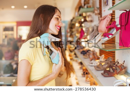 woman with closed eyes and great pleasure holding the best shoes in a shop