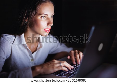woman using computer late at night, isolated on black background