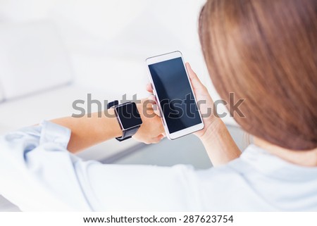 woman using smart watch and smart phone (focus on phone). App template