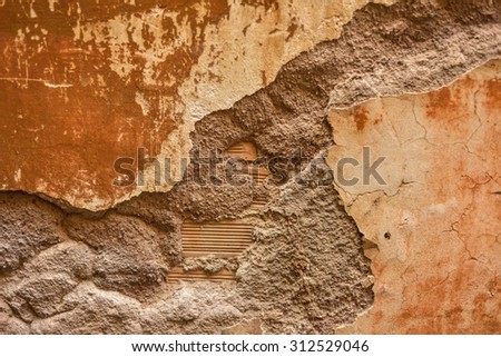 This is a horizontal, selective focus shot of an exposed wall on a building in Rome, Italy. This crumbling wall shows the many layers of Rome's ancient building styles.