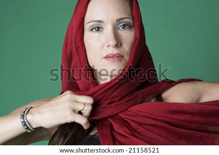 Exotic looking woman portrait on a plain green background