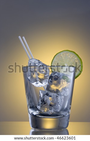 Club Soda on the rocks with lime slice garnish on plain background