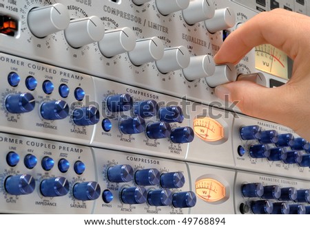 Audio engineer\'s hand operating studio devices for a music production