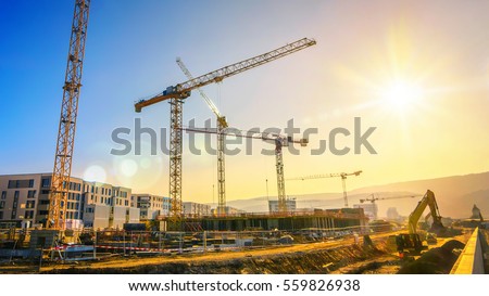 Large construction site including several cranes working on a building complex, with clear blue sky and the sun ストックフォト © 