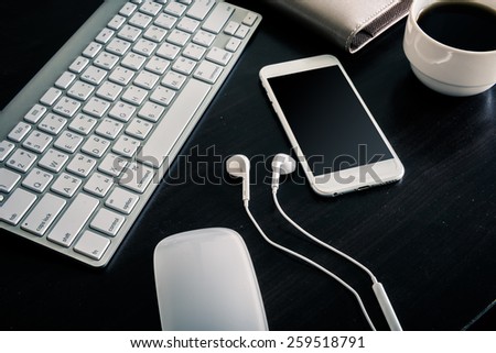 Office table with notebook, computer, coffee cup , computer keyboard, smartphone , headphone. with copy space