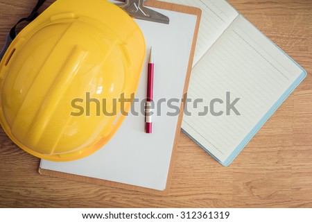 safety helmet, clipboard, notebook, pen on wooden table. top view. Construction concepts