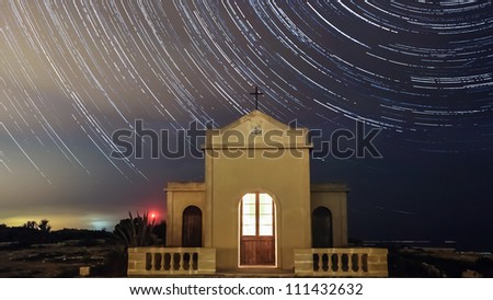 Extreme long exposure image showing star trails around the Polar Star or Polaris in sky over chapal in Ahrax Point Malta