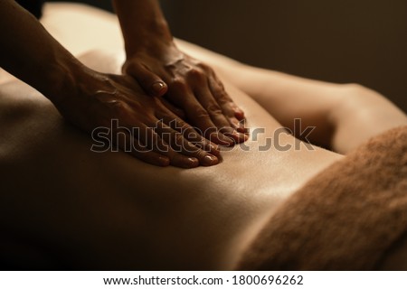 The beautiful girl has massage. Authentic image of luxury spa treatment. Warm colors, charming light.