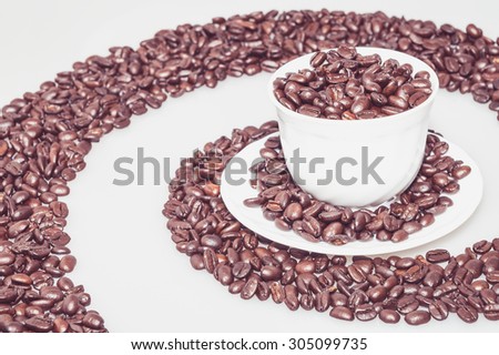 Cup full of coffee beans inside a coffee whirl