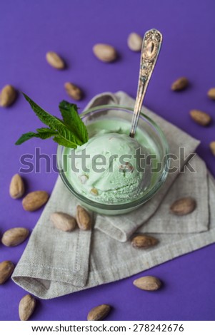 pistachio ice cream with mint leaves on a purple background