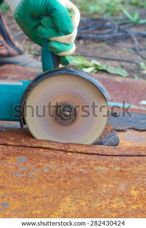 Angle grinder cuts rusty metal plate sparks vent
