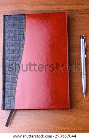 Notebook and pen on the wooden table