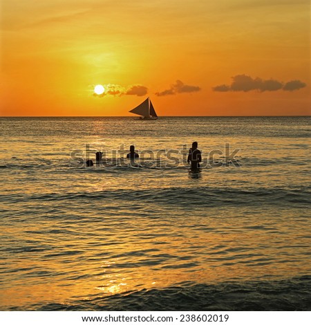 BORACAY BEACH,PHILIPPINES-FEBRUARY 24, 2014: Sailing people on the boat at the sunset