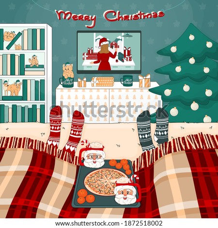 Christmas pizza, cocoa with marshmallows, TV set, bookcase, tree, bed with plaid, toys, gifts are in the room. Two people are watching movies under the plaid in knitted socks