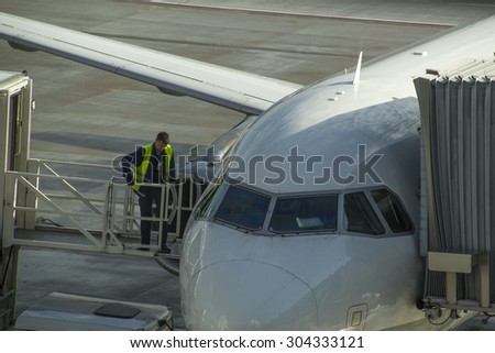 Munich, Germany - October 16, 2014: Technician from Ground crew working below a passenger airplane.