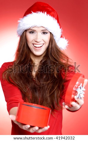 Portrait of beautiful brunette woman wearing santa claus hat on red background