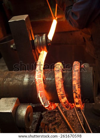 red hot bars being coiled into springs,Sheffield,Britain. taken 15/02/2014