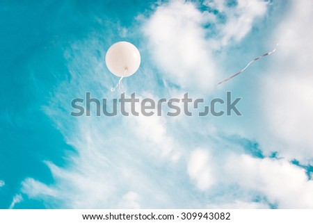 White balloon in blue sky background. Concept for freedom, following dreams or making a wish.