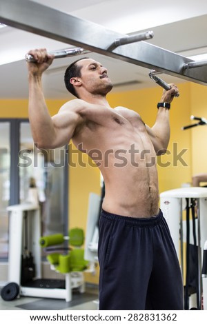 muscular bodybuilder training back muscle in fitness center
