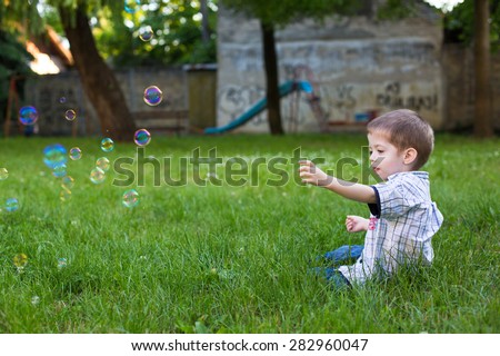boy and bubbles in a little park with graffiti wall