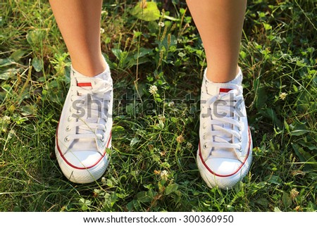 Sport Footwear on Female Feet on Green Grass