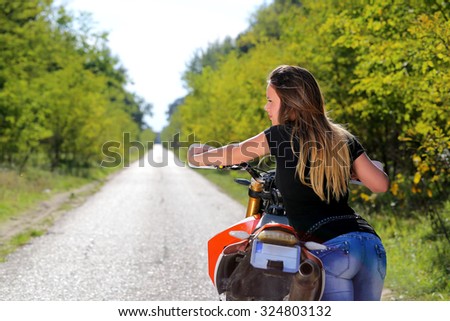 young woman moving the motorbike on the road