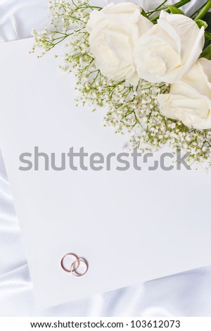 Wedding rings with a roses and invitation