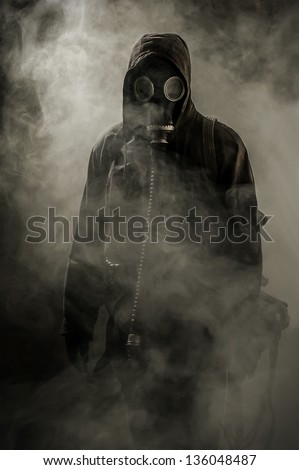 Portrait of a man in a gas mask in smoke after the crash