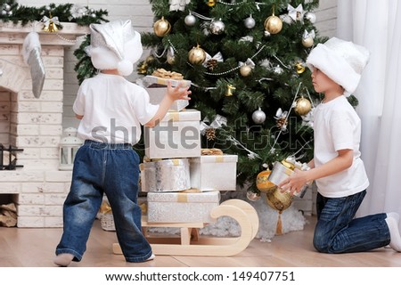 Children under the Christmas tree with gifts and toys