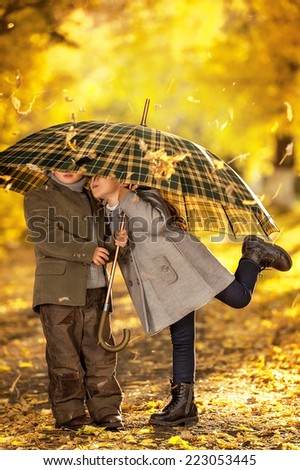 Boy and girl walk in autumn park on a warm sunny day