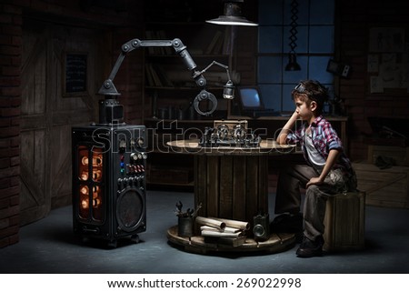 Boy mechanic robot helper playing chess in the studio in the evening