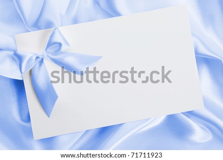 The wedding invitation with a bow on a blue background