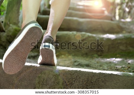 woman climbing stone steps to success
