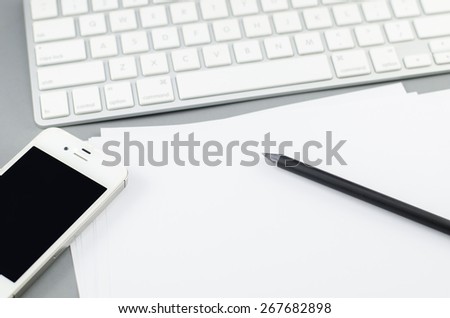blank paper with pencil and smart phone on Computer desk