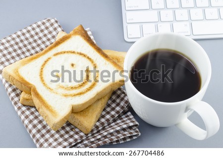 Morning coffee and toasted bread with smiling burn mark