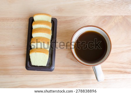 Coffee and slice of butter cake on wooden table