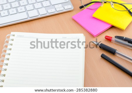 Notebook with pen and color note paper on Computer desk