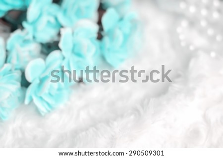 Blur carnation flower background with pearl necklace and white fur with place for text - blue tone