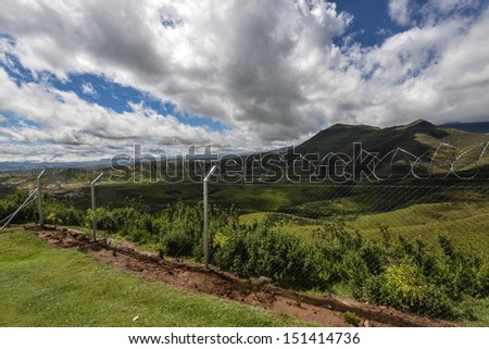 Monantsapas fenced border crossing between South Africa and Lesotho with the mountains of Lesotho in the background.